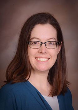 A profile shot of Dr Ann Wheeler, wearing a blue cardigan with a white top underneath